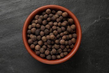 Dry allspice berries (Jamaica pepper) on black table, top view