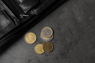 Poverty. Black wallet and coins on grey table, top view. Space for text - obrazy, fototapety, plakaty