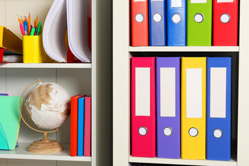 Colorful binder office folders and other stationery on shelving unit