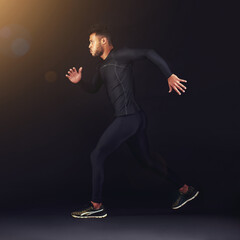 Running, fitness and man with workout, exercise and training on a black studio background. Person,...