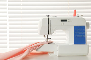 White sewing machine and fabric on light table indoors