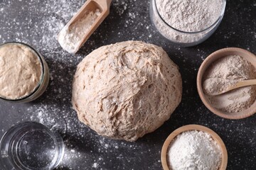Fresh sourdough, flour and water on grey table, flat lay