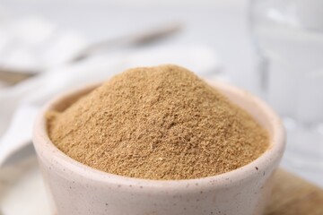 Dietary fiber. Psyllium husk powder in bowl on table, closeup