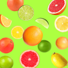 Fototapeta premium Many different fresh citrus fruits in air on light green background