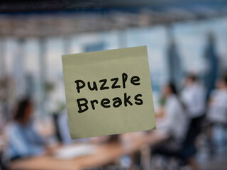 Post note on glass with 'Puzzle Breaks'.