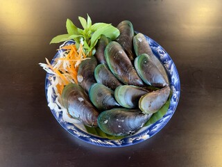 Steamed mussels with basil leaves, selective focus