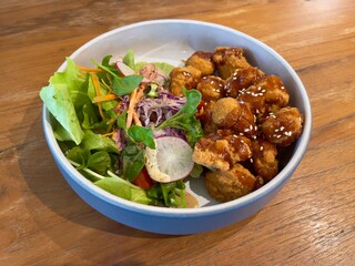 Crunchy chicken popcorn dressing with sweet teriyaki sauce and served with fresh vegetables, selective focus