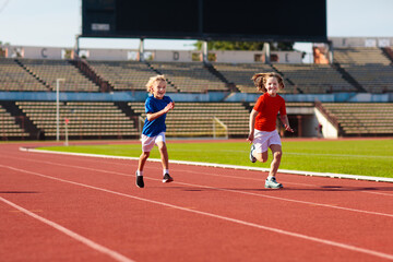 Child running in stadium. Kids run. Healthy sport.