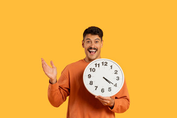 Man with moustache posing with clock showing time