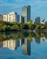 Fototapeta premium Vertical shot of trees ad buildings reflecting in the water.