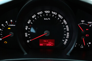 Close up Car dashboard with lights symbols. A close-up of the speedometer and tachometer.