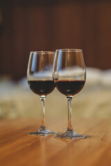 Two glasses filled with red wine, in a cozy apartment 