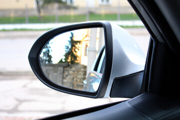 Inside view of car mirror. Look in the rear view mirror of a car. Side rear-view mirror on a car.