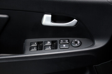 Window control buttons on cars. Car interior details of door handle with windows controls and adjustments. Car window controls. Door handle with power window control.