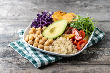Healthy salad with avocado,lettuce,tomato and chickpeas on wooden table