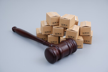 Taxes and tariffs concept. Gavel and many carton boxes on gray background.	
