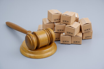 Taxes and sanctions concept. Wooden gavel and many shipping carton boxes.