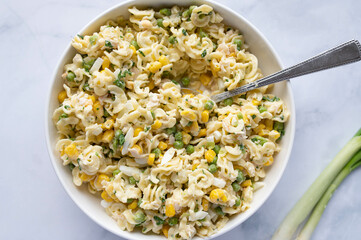 Low fat and high protein  pasta salad with chicken breast, geen peas, corn and herbs in a bowl