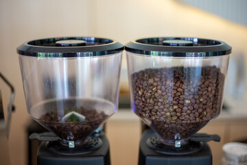 selective focus coffee bean grinder in coffee shop There are tons of coffee pellets all over the visible grinder.