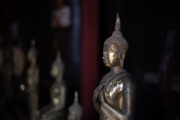 selective focus old brass Buddha statue in the dark In a temple in Thailand There is space for text.