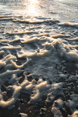 Vertical shot of a beautiful sea captured from a rocky shore during a mesmerizing sunset