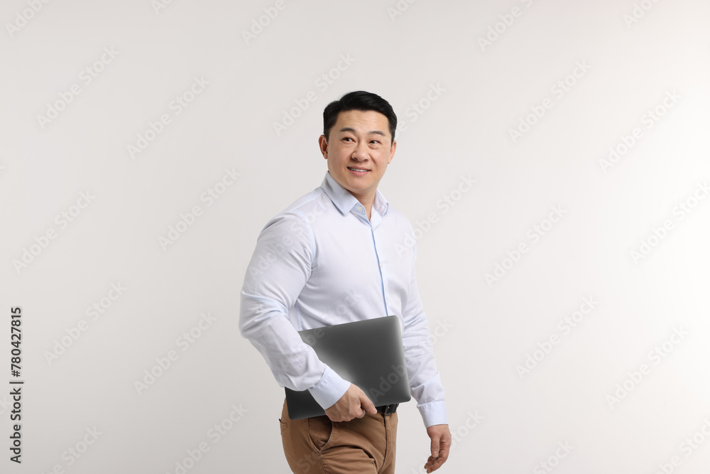 Poster Portrait of happy man with laptop on light background