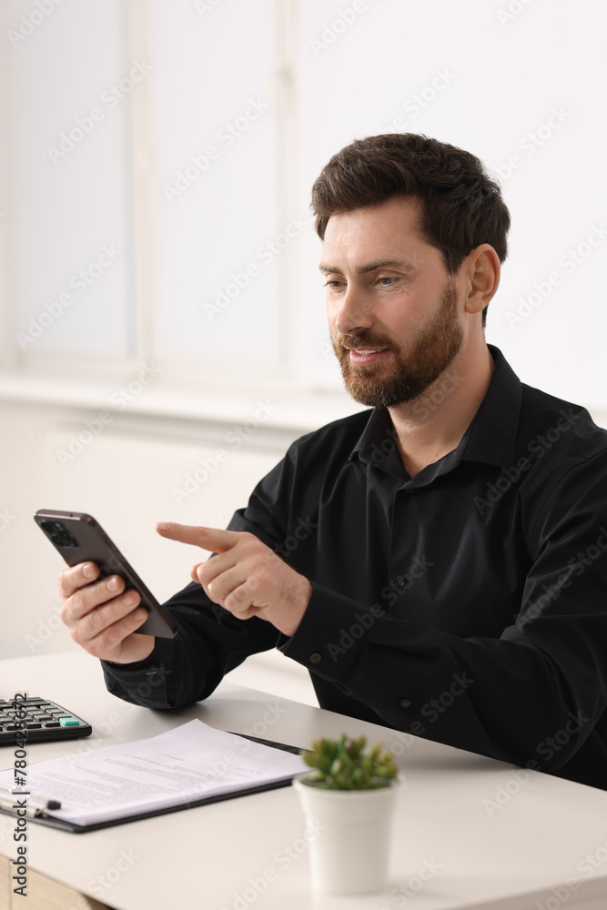 Aufkleber smiling man using smartphone at table in office