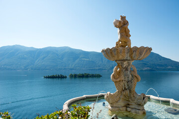 Fountain Statue with View Over Lake Maggiore with Brissago Islands and Mountain in a Sunny Day in Ronco sopra Ascona, Ticino, Switzerland.