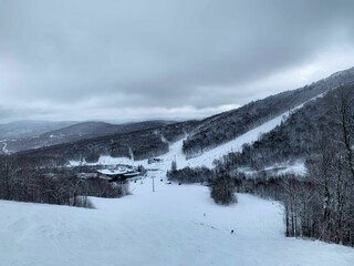 Obraz premium Scenic shot of hills covered with snowy trees in Killington Ski Resort, Vermont, New England, Canada