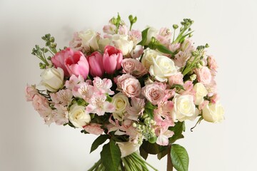 Beautiful bouquet of fresh flowers near white wall