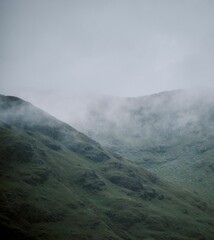 Vertical shot of the green mountains in Ireland on a foggy day