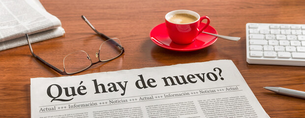 A newspaper on a wooden desk - Whats new in spanish - 780434273