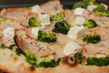 Closeup shot of details on a gourmet pizza with broccoli and cheese toppings