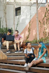 College, campus and students relax on stairs with social community, friends and chat about course....