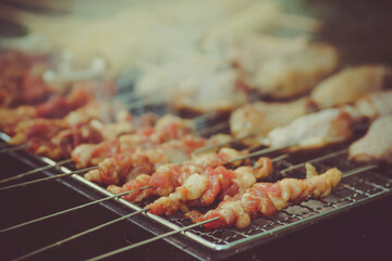 Closeup shot of meat on sticks being barbecued on a brazier - obrazy, fototapety, plakaty