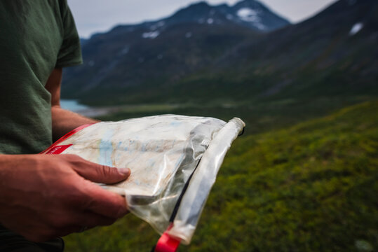 Cropped image of man holding map in plastic bag while hiking