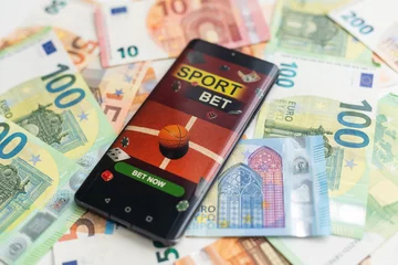 Gordijnen Sports betting website in a mobile phone screen, money © Angelov
