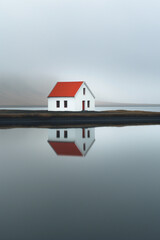 Solitary house with red roof on small island, serene minimalist landscape, perfect for calm and solitude themes.