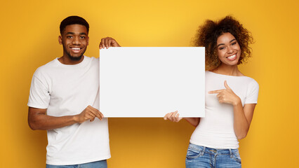 African-american man and woman posing with white empty board