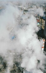 Vertical aerial shot of the environment of a city in smoke, industrial factories