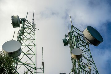 Low-angle shot of a tower with microwave links and TV transmitter antennas - obrazy, fototapety, plakaty