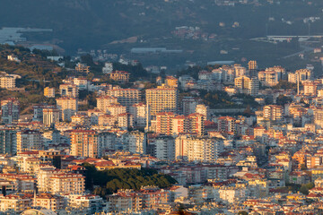 Fototapeta premium Panoramic view from Alanya Castle on city Buildings during sunset