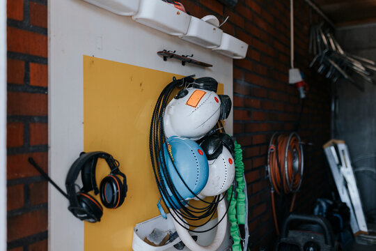 Hardhats and ear protectors hanging on wall