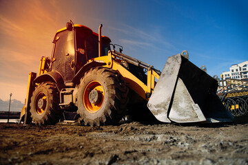 Excavator loader machine at demolition construction site , sunset time .  Powerful earthmoving...