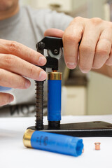 A man make repairing of plastic case for making a cartridges for shooting