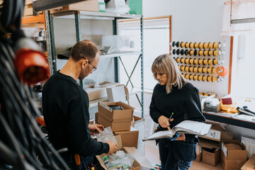 Two people checking items in workshop