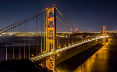 Beautiful view of the Golden Gate Bridge at night with bright yellow lights under the dark sky