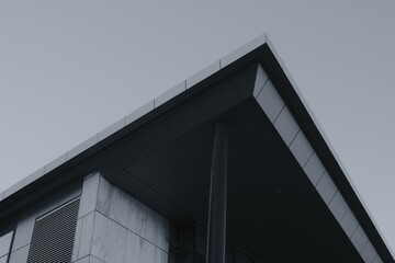 Low angle grayscale shot of a triangular modern building roof