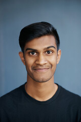 Smile, fashion and portrait of man in studio with positive, good and pride attitude with confidence. Happy, handsome and face of Indian male person with casual or trendy style by gray background.