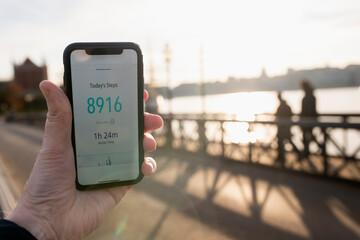 Hand of unrecognizable person using activity tracker through smart phone app